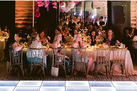 Corporate event - the group sits at a banquet table for dinner next to a dance floor