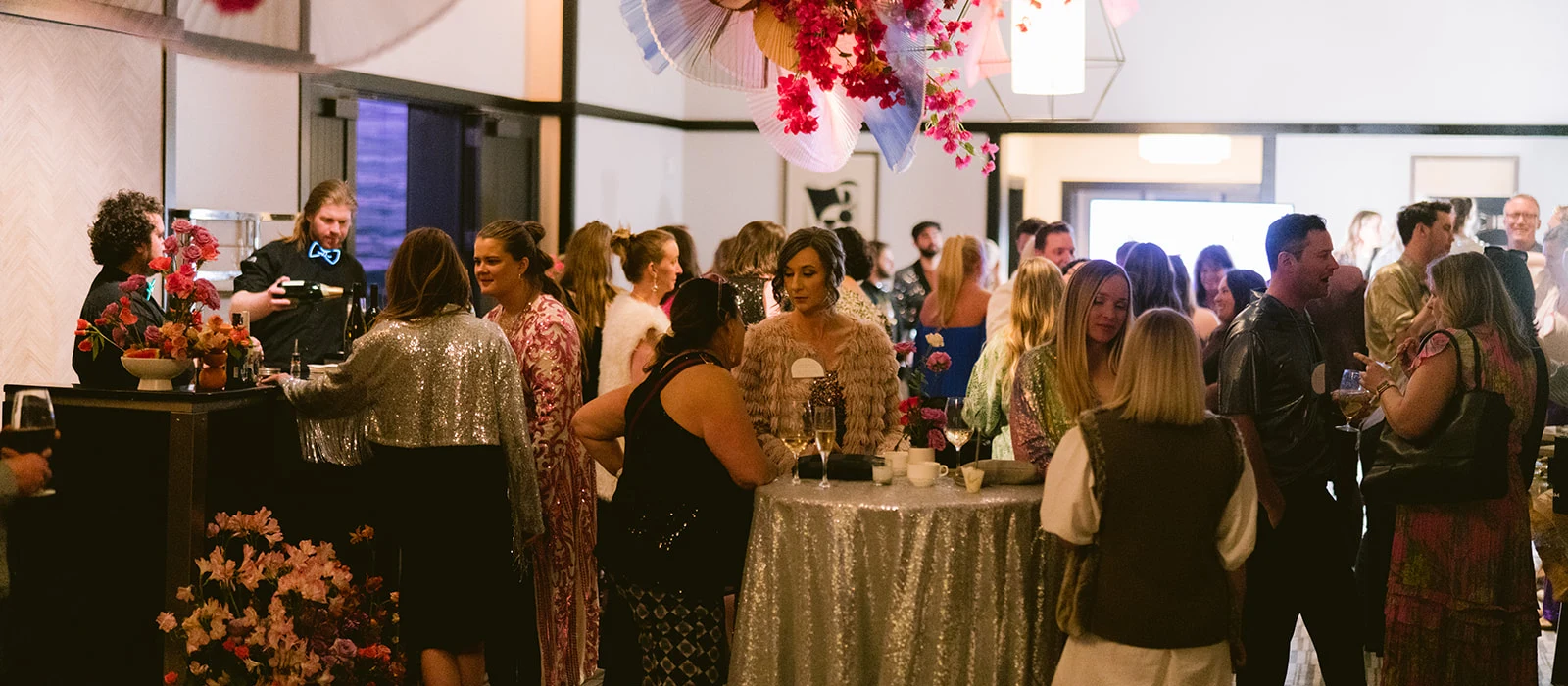 People talk around standing tables at a large event