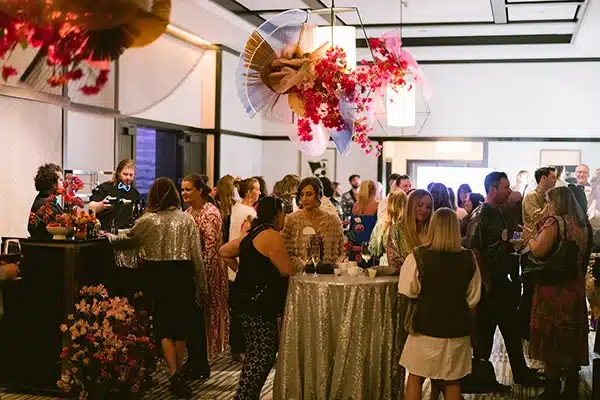 Anywhere 37 People talk around standing tables at a large event
