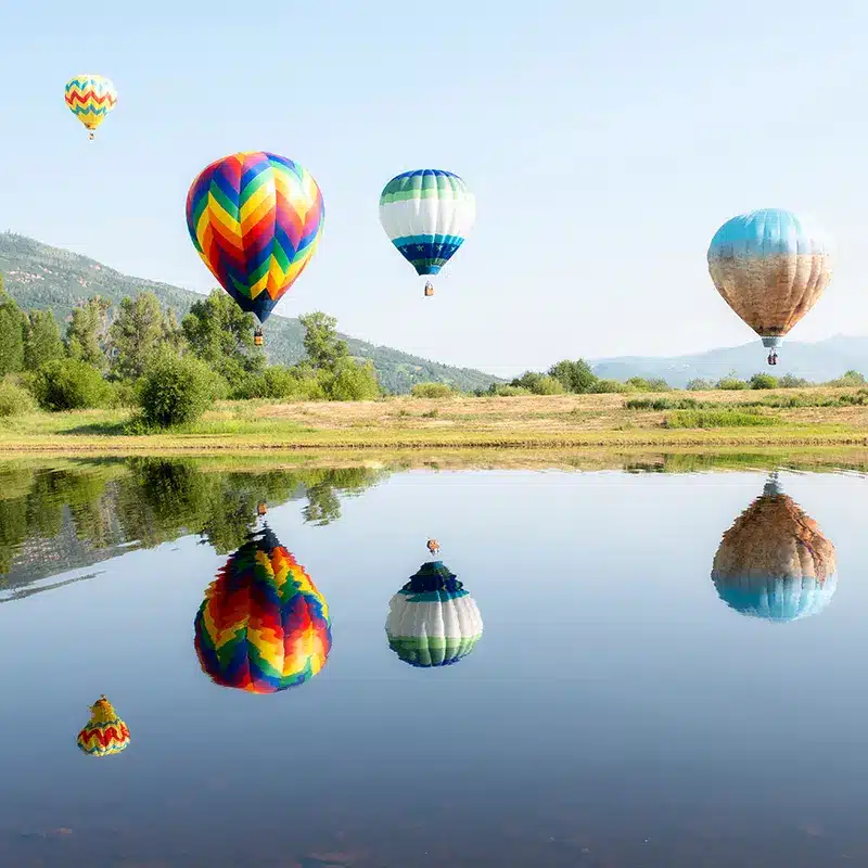 steamboat_445429778 Hot Air Balloons Over a Lake with Reflections in Steamboat Springs, Colorado